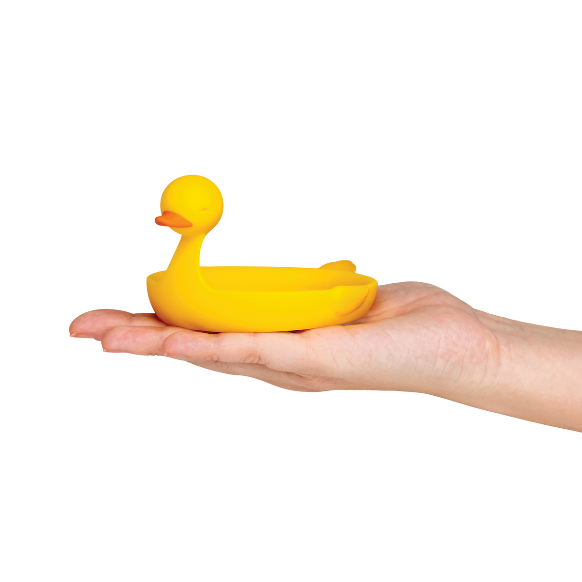 A hand holds the Sunny Side Duck, a small yellow duck-shaped egg separator, against a white background.